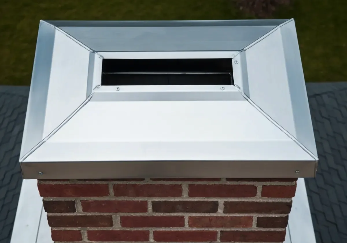 After — chimney cap installation: A bare, open flue crowned with a stainless cap against rain, birds and squirrels.
