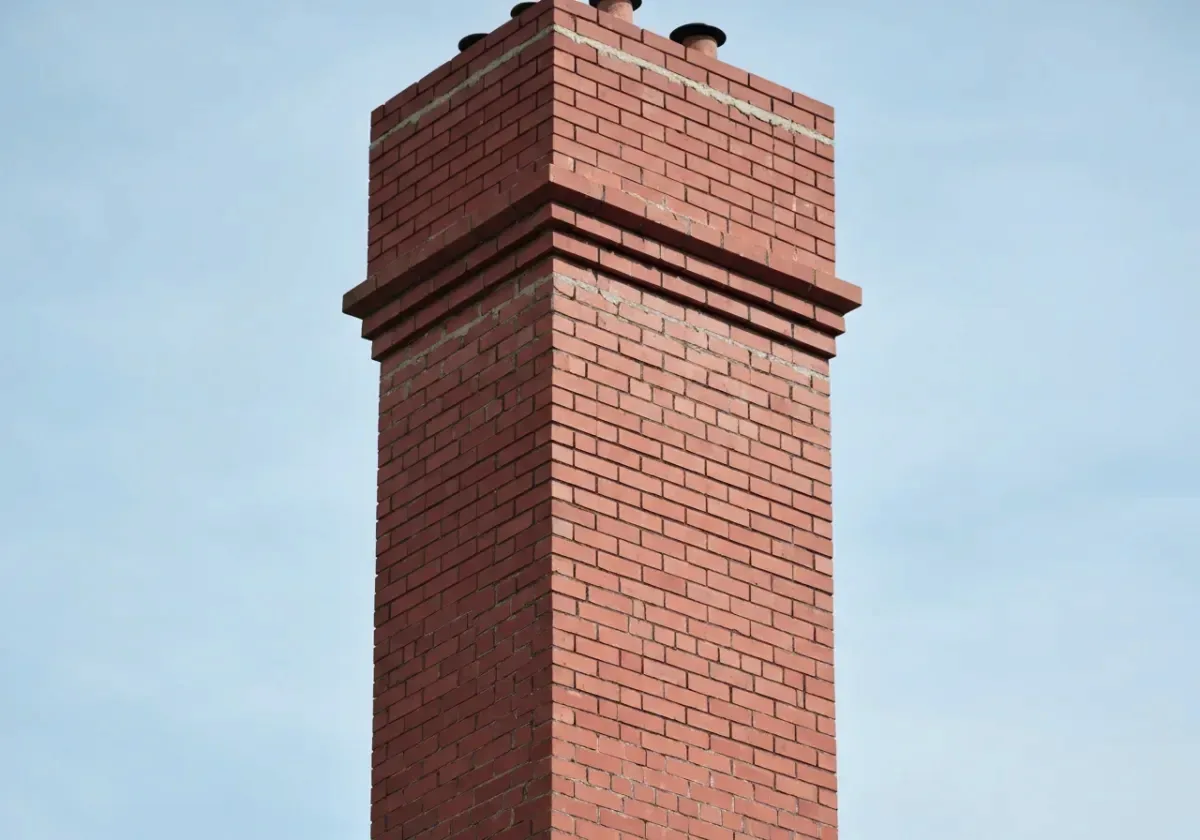 After — chimney repair: Flaking brick and washed-out mortar rebuilt into a tight, weatherproof stack.