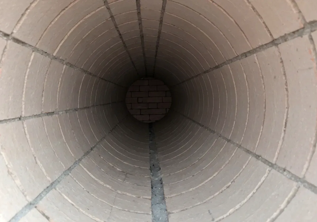 After — creosote removal: Hard glazed creosote stripped from the flue walls — the fuel of a chimney fire, gone.